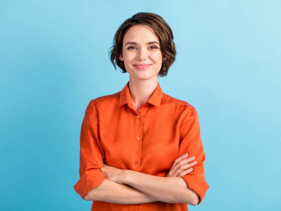 Photo of attractive charming lady cute bobbed hairdo arms crossed, self-confident person worker friendly smile good mood wear orange office shirt isolated blue color background